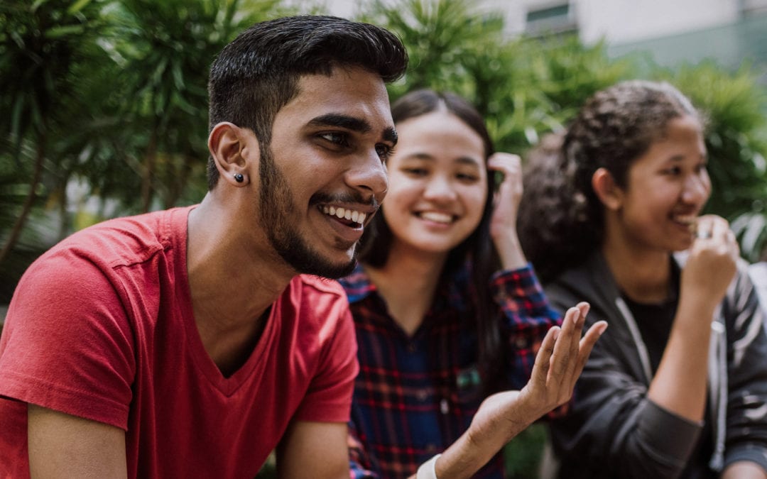 Mixed group of young adults laughing and talking