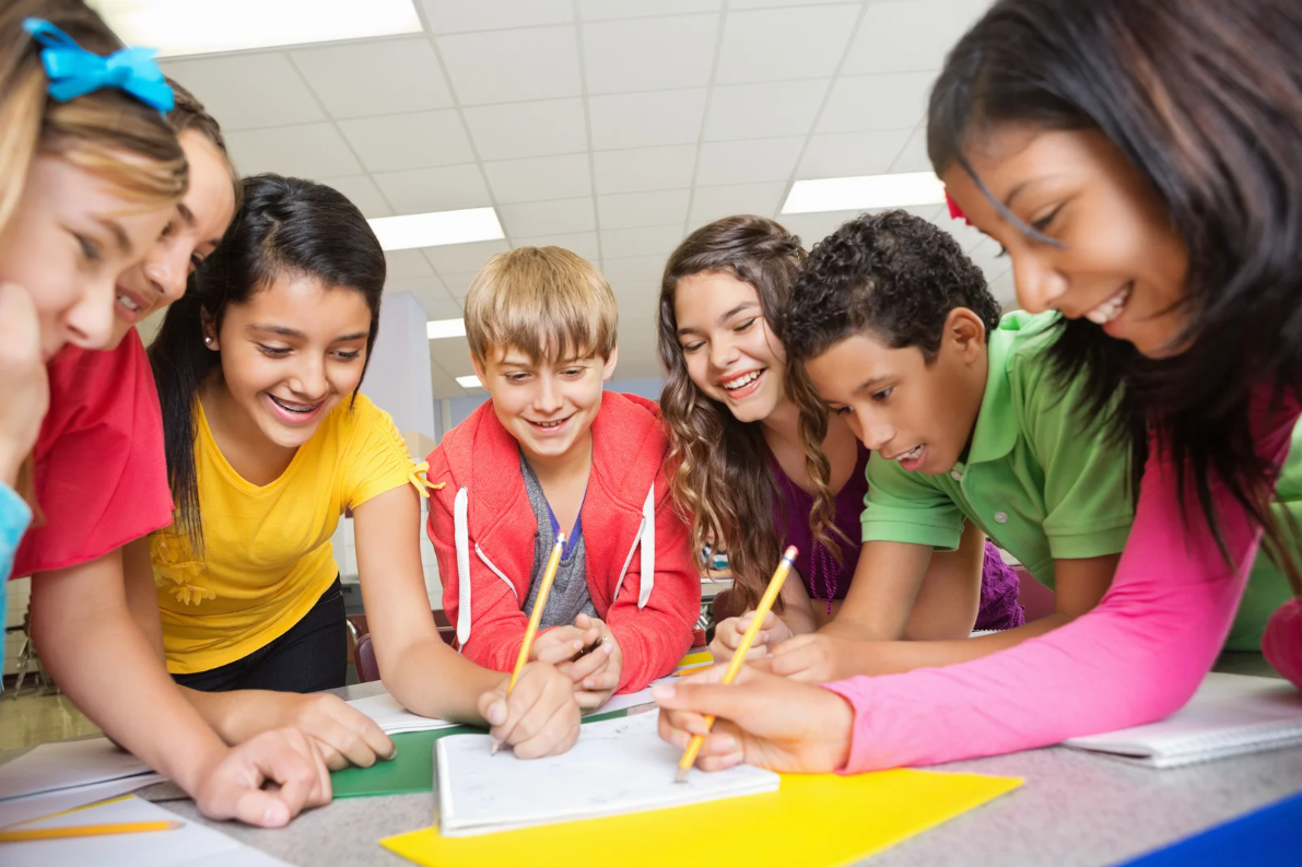 Teacher helping pupils in classroom at the elementary school